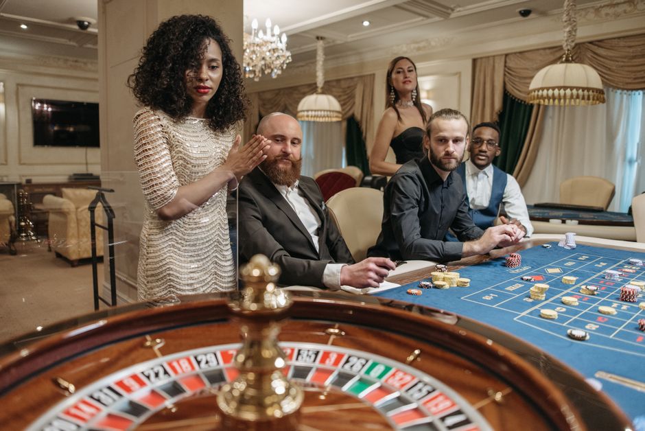 A group of people enjoying a night of roulette at a luxurious casino.
